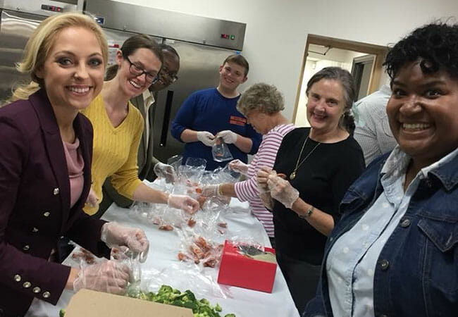 Andrea Hill, right, is joined by Miss Tennessee Caty Davis and fellow Volunteer Tennessee board members for a food preparation service project at the YMCA of Metropolitan Chattanooga.