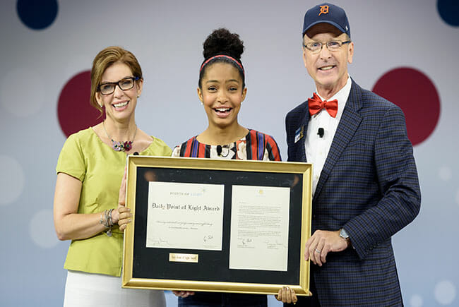 Yara Shahidi received the Daily Point of Light Award from Points of Light CEO Tracy Hoover and Chairman Neil Bush, following her speech at the closing plenary of the 2016 Conference on Volunteering and Service.