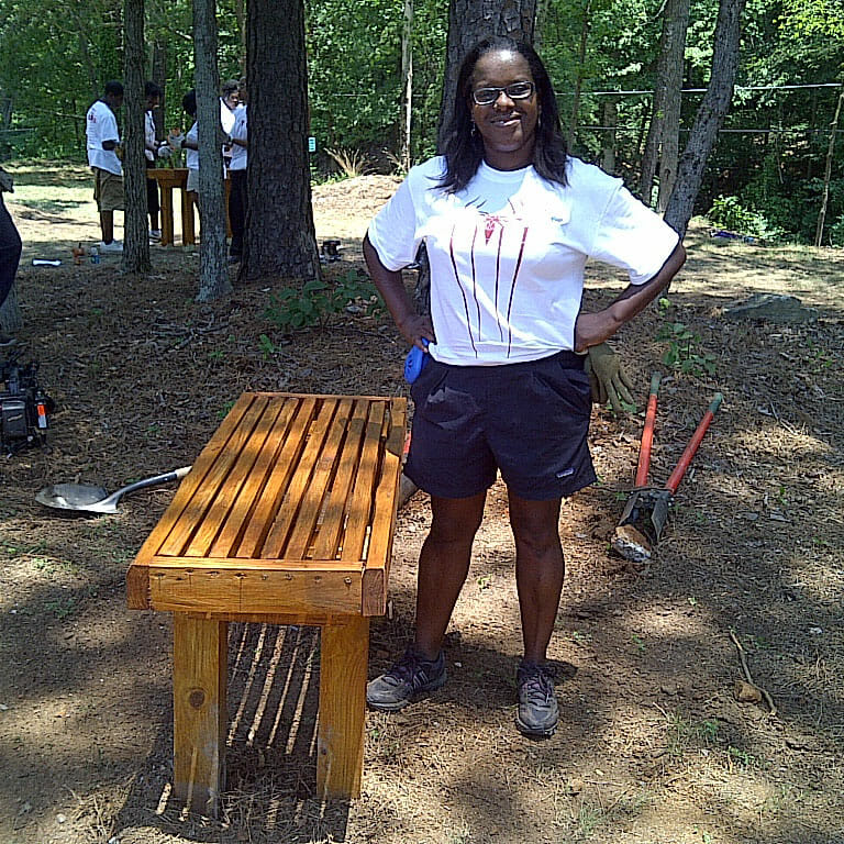 ReGina standing in front of her completed bench at a Hands On Atlanta event./ Courtesy ReGina Dobson