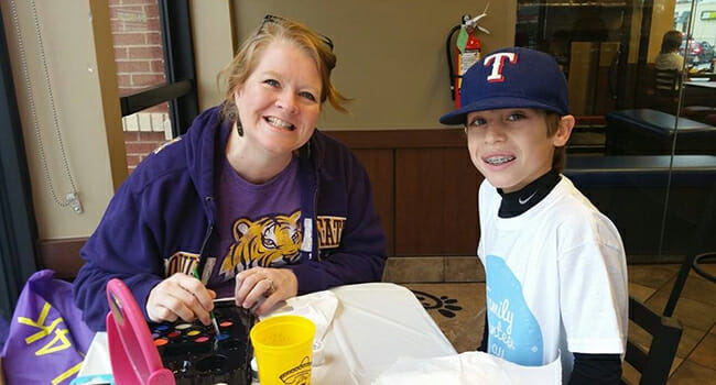 Melanie Rutecki and Zach Morgan, founder of Lidz for Kidz, running a face painting station at a 2015 Family Volunteer Day event.