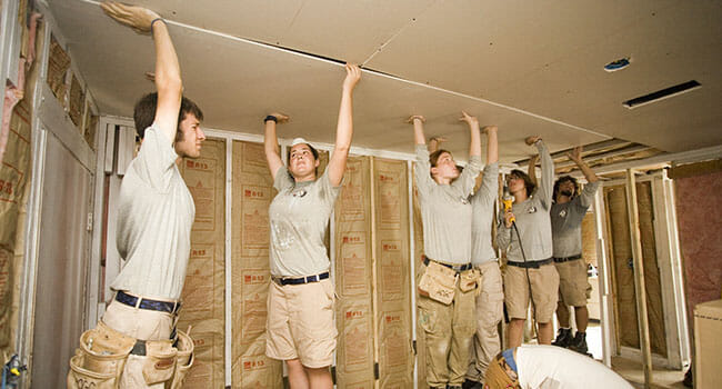 AmeriCorps members working with HandsOn Gulf Coast place a new ceiling in a Biloxi, Mississippi, home damaged by Hurricane Katrina.