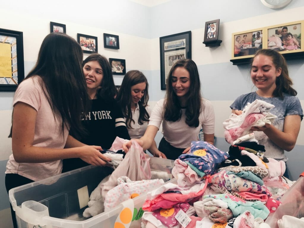 Emi (second from right) and her recruits sorting clothes at the Good+ Foundation warehouse./ Courtesy Emi Silverstein