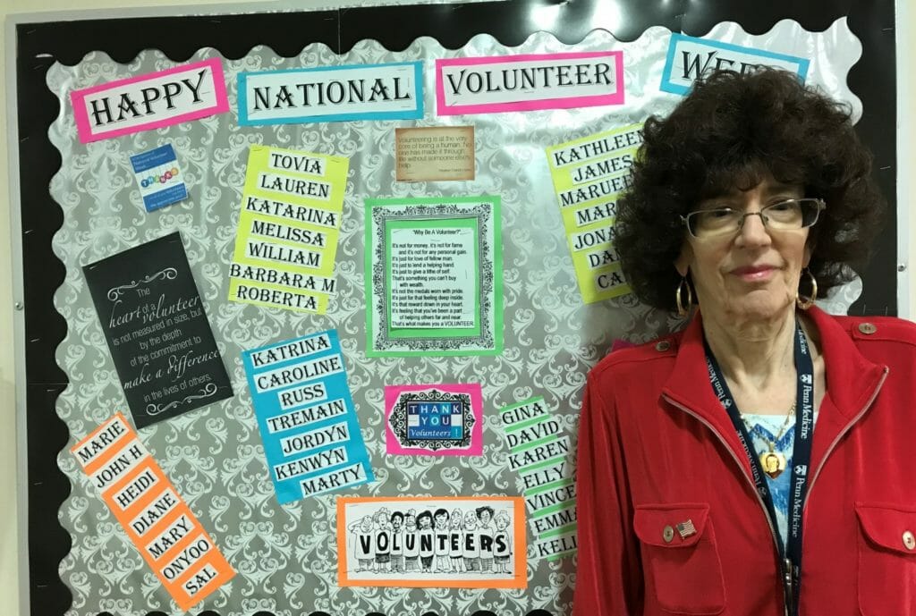 Barbara Manfriedi pictured in front of a board celebrating volunteers at Penn Wissahickon Hospice during National Volunteer Week./Courtesy Barbara Manfredi