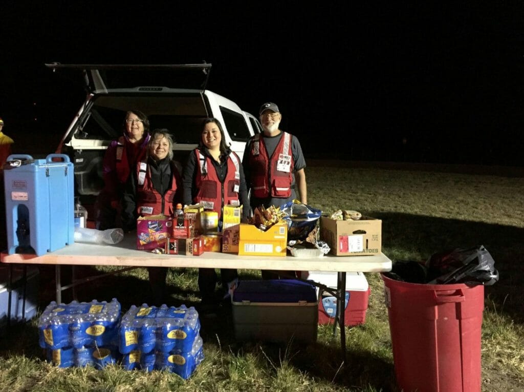 Kathy (second from left) supporting firefighters with refreshments during a grass fire as a Red Cross volunteer./Courtesy Kathy Deml