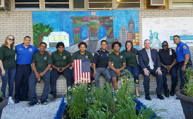 Students from Usher's New Look and NYC Together with officers from the 90th precinct at the unveiling of the mural they created together.