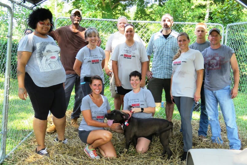 Sylvia Mayon (bottom row, left) with the Break the Chain Kennel Kru after building a kennel for Caynan, who had been housed in a wire crate./Courtesy Sylvia Mayon