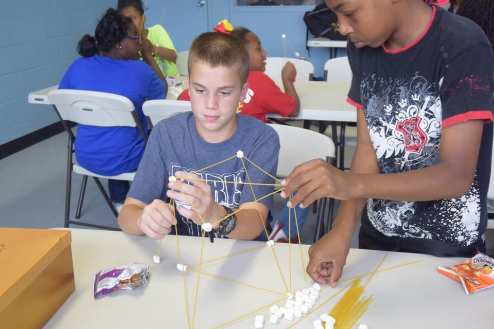Curt Fendley (left) and Operation Empower members participate in a spaghetti/marshmallow tower building STEM activity at the Boys and Girls Club in Paris, Texas./Courtesy Curt Fendley