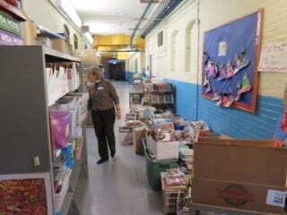 Mimi inspects the halls of the new library at Sara Greenwood where 6,000 books wait to be shelved by volunteers./Courtesy Mimi LaCamera