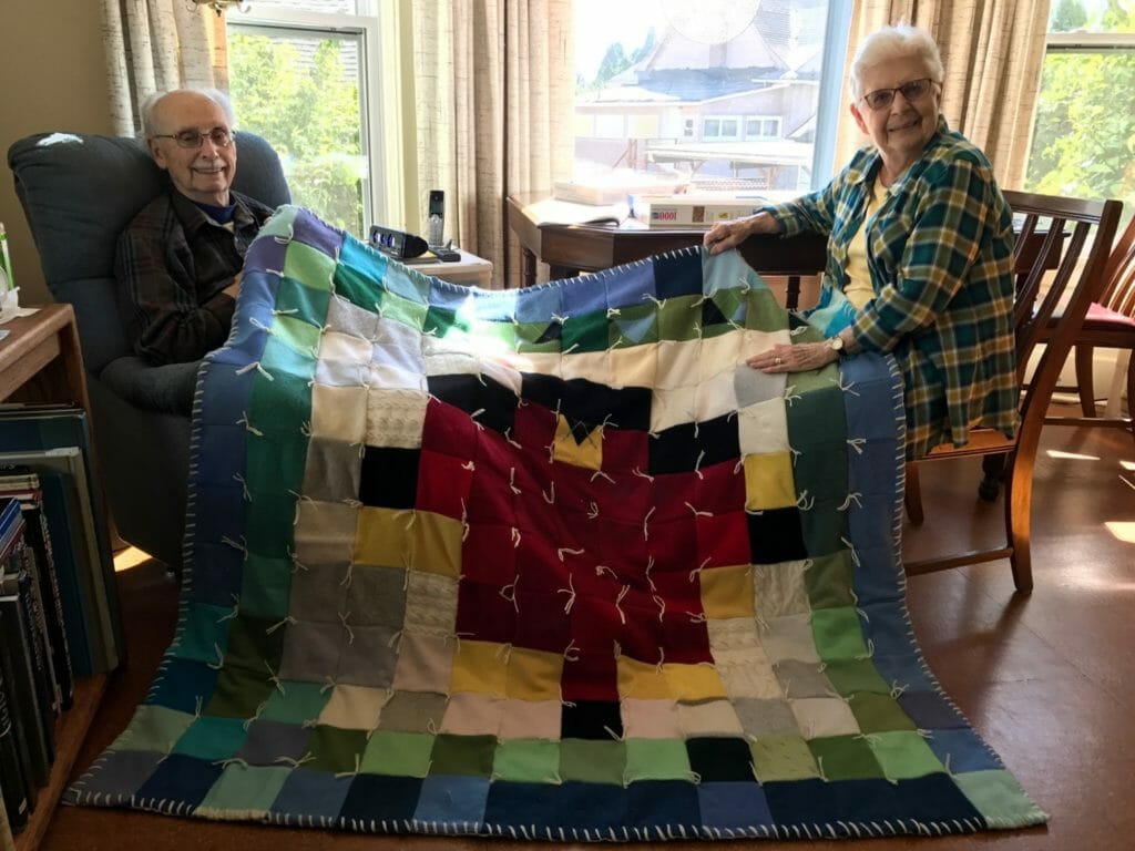 Pearl (right) holding up one of her quilts./Courtesy Pearl Conkle