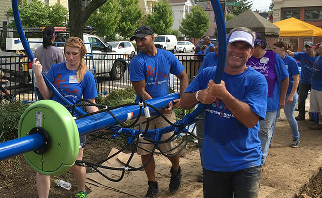 Employees of Dr Pepper Snapple, the 2016 Civic 50 sector leader for consumer staples, volunteer at a playground build. The company built or renovated more than 2,500 playgrounds and provided new sports equipment to hundreds of organizations in 2016. DPS employees also contributed more than 35,000 volunteer hours.