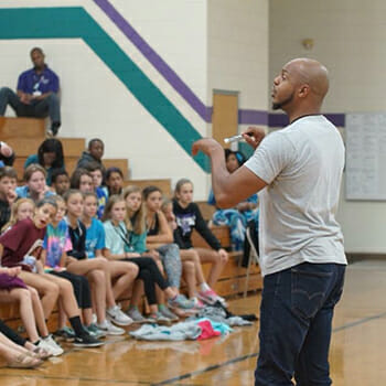 Devine speaks to students about the power of words, and encourages them to use their voice and empower others to act.