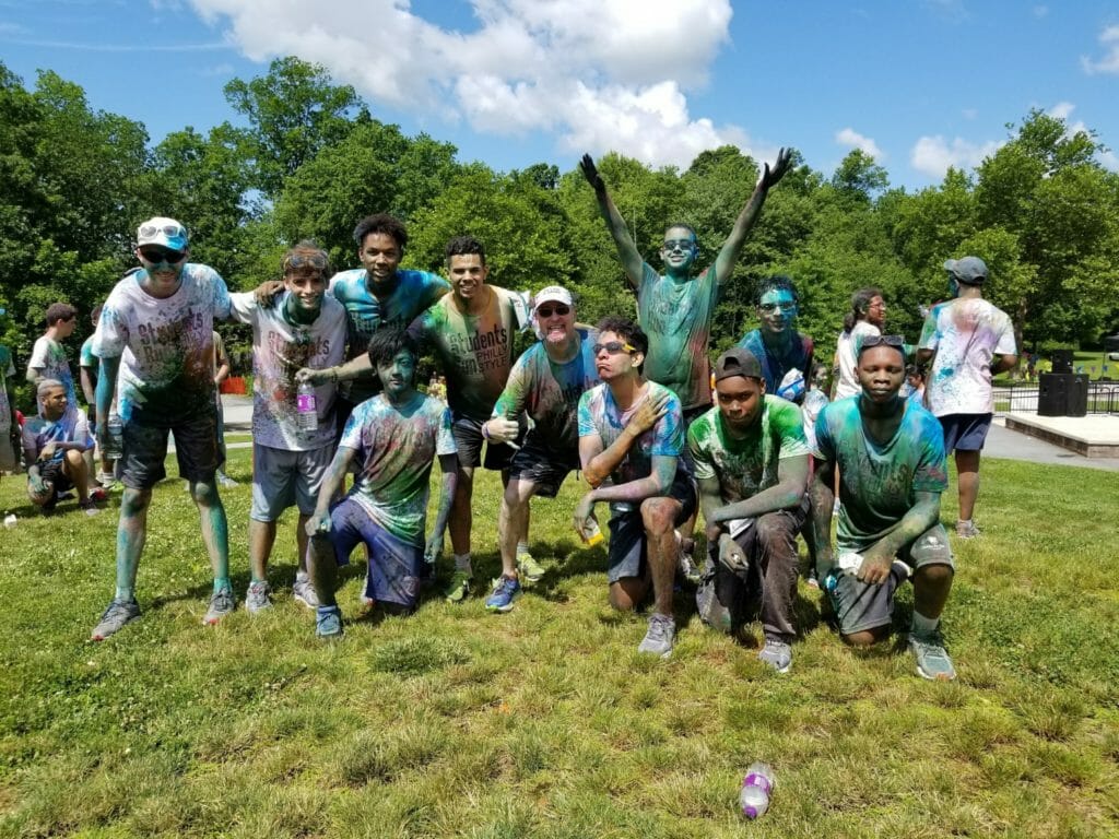 Luis Gaitan (fifth from right) along with volunteers and kids after a color run at a student-run youth leadership summer retreat./Courtesy Luis Gaitan