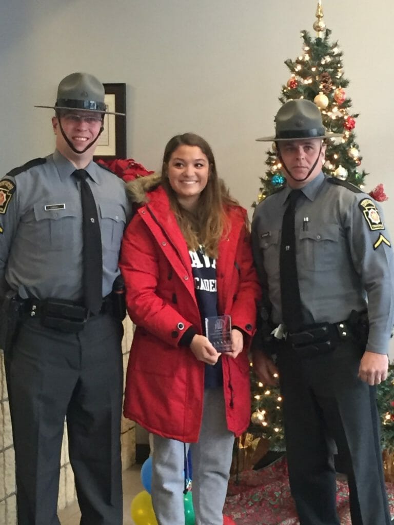 The Commonwealth of Pennsylvania State Troopers and Lift Johnstown Committee surprising Beth (middle) with the 17th Lift Johnstown Volunteer Spotlight Award./Courtesy Beth Felix