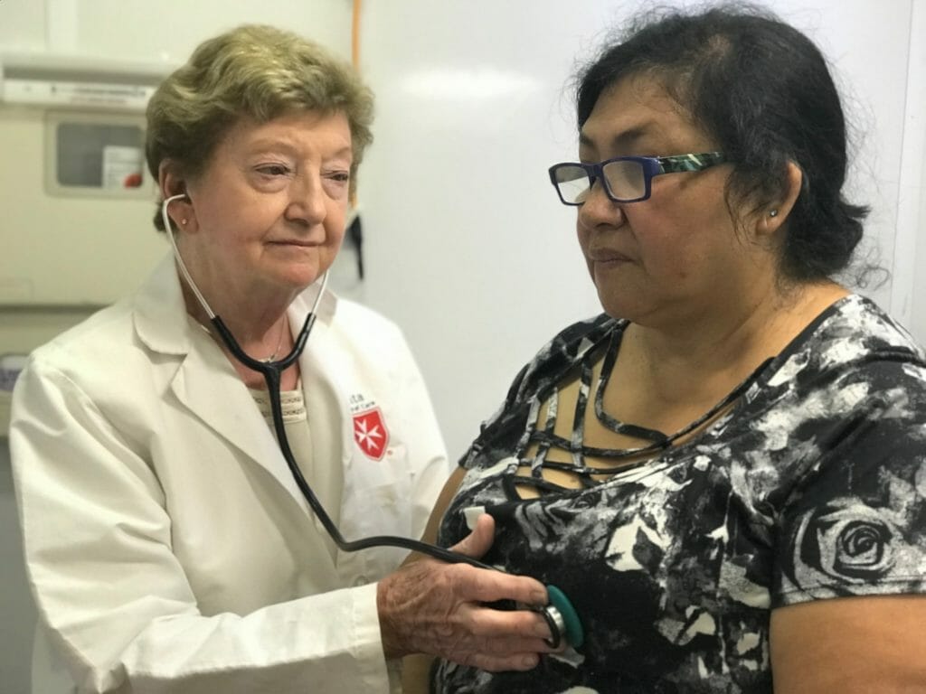 Dr. Olsen meets with a patient who has regularly utilized the Malta van as a health care resource./Courtesy Pauline Nagle Olsen