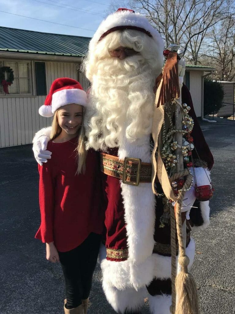 Emma with Santa Claus delivering hundreds of gifts made possible by donations from local community members./Courtesy Mary Bishop