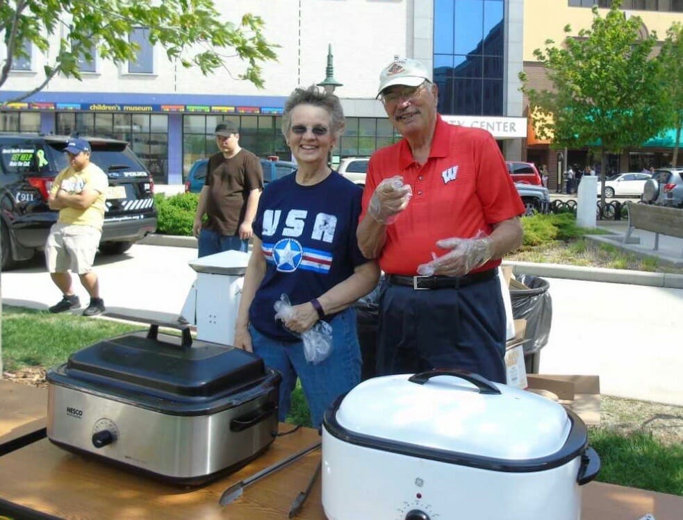 Kristen Larson-Smith (Left) volunteering at the annual Police Week Brat Fry, where she volunteers annually and serves food to hundreds of visitors./ Appleton Police Department