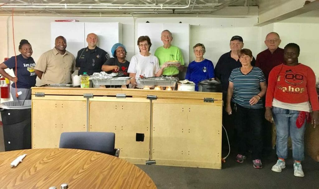 Kristen (fifth from right) volunteering with the APD team at Outside the Box Breakfast, serving food to the homeless./Courtesy Appleton Police Department