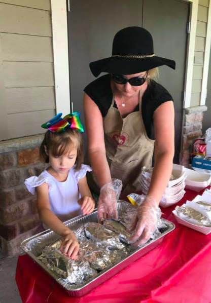 Jessica with daughter Chloe passing out hot dogs at an ACS event in May./ Courtesy Jessica Richardson