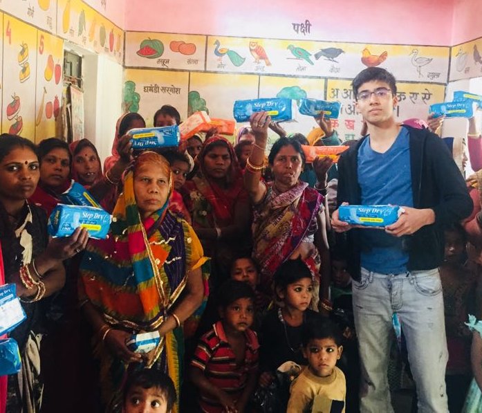Ansh Jain helps distribute sanitary napkins to women in poor villages in India.  Some of the women are seeing these products for the first time./ Courtesy Ansh Jain