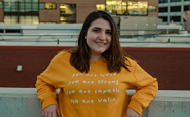 Gabby Frost, founder of the Buddy Project, shows off one of the organization’s signature “You Are” shirts during Mental Health Awareness Month, photo courtesy of Lexi Shannon.