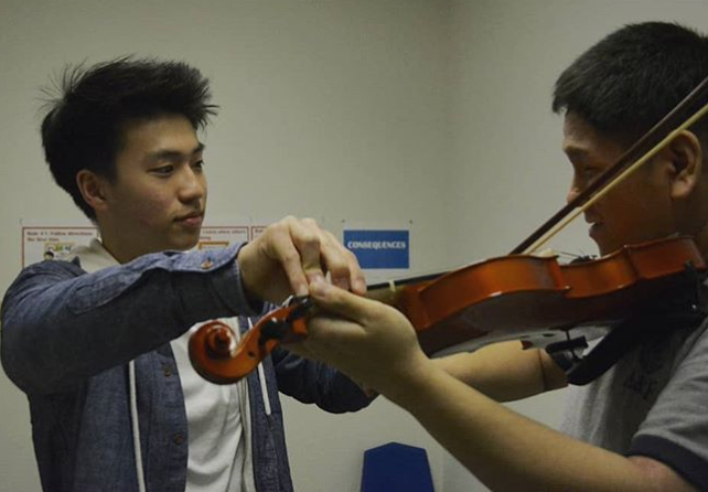 Joseph Choe working with his autistic student on their weekly violin lessons./ Courtesy Joseph Choe