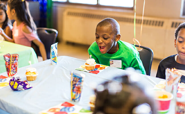 A celebrate! RVA child blows out his birthday candle and makes a wish.