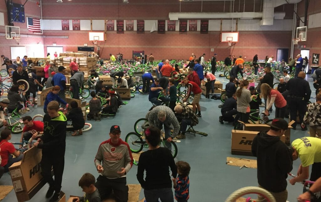 Hundreds of volunteers help to assemble bikes to donate to students for Bicycles for Children in the days leading up to delivery, before Christmas Day./Courtesy John White