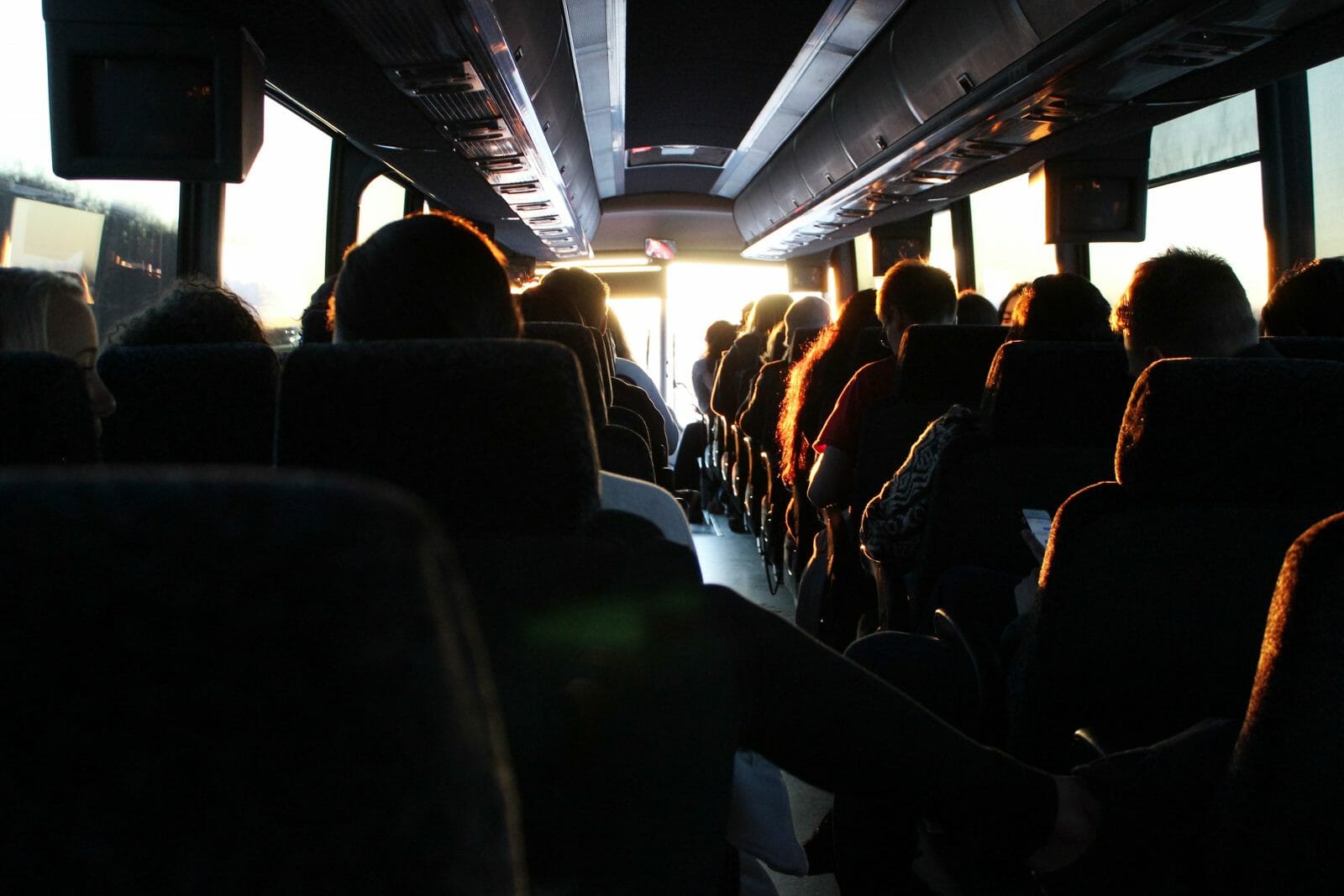 Interior of a bus with silhouetted passengers