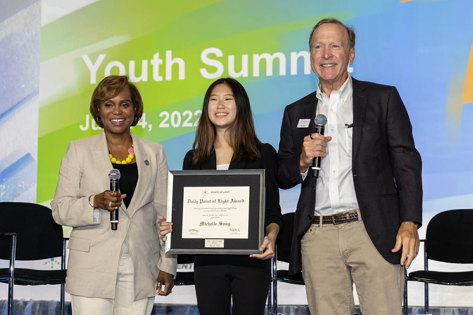 Michelle Song receives Daily Point of Light Award from Points of Light President and CEO Natalye Paquin and Board Chair Neil Bush